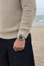 Homme portant une montre Emir Watches de couleur verte avec des chiffres arabes